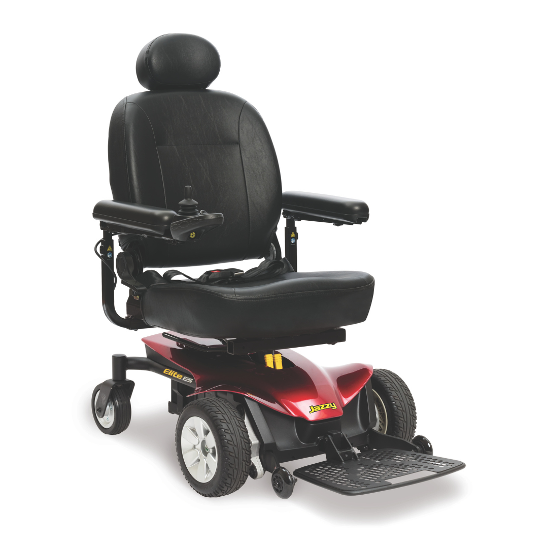 A Pride Mobility Jazzy® Elite ES Powerchair in black and red, featuring a high-back seat, padded armrests, headrest, footrest, and arm-mounted joystick control, shown against a white background.